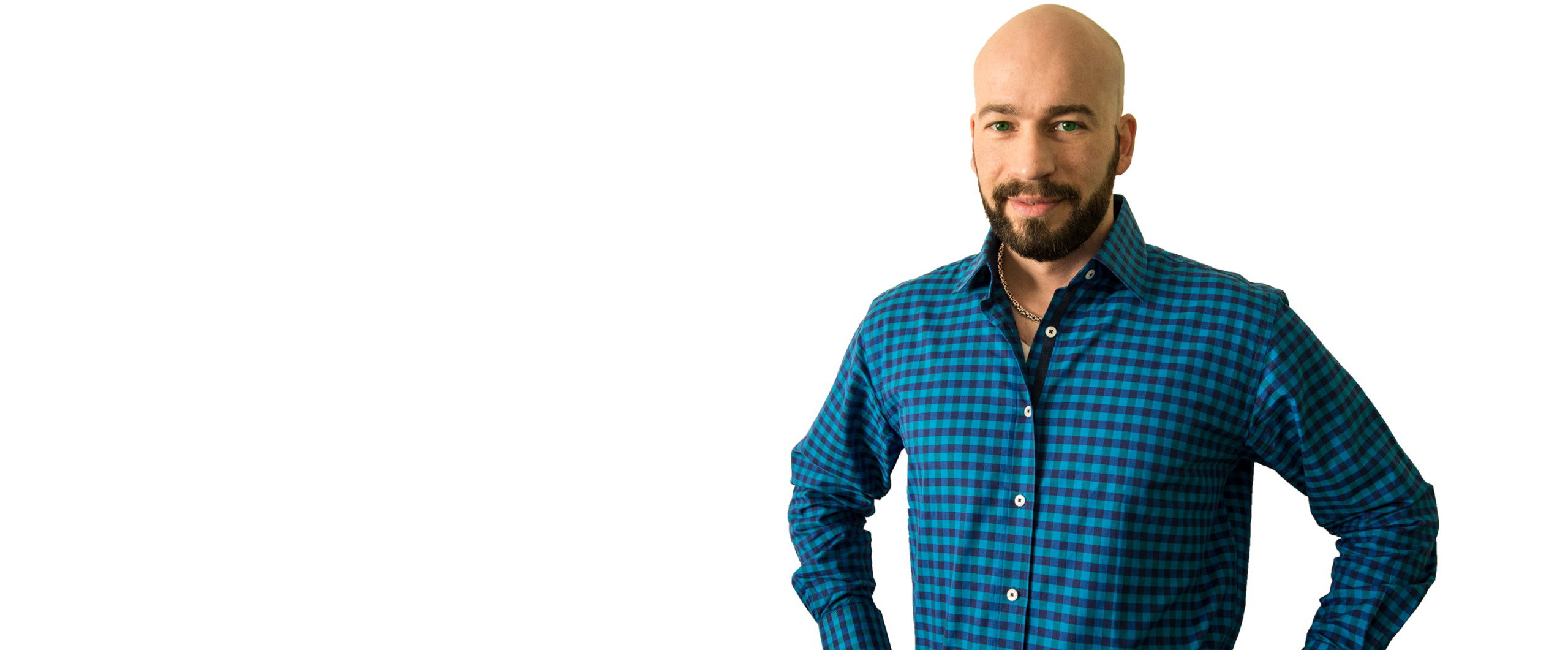 David Dubé in a blue gingham shirt, hands on hips, smiling at the camera.
